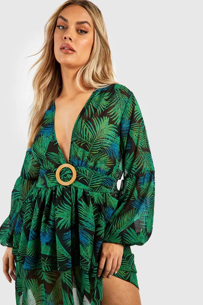 model in dress with plunge neckline and palm print pattern