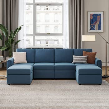 u-shaped sofa in navy with upright pillows in style living room 