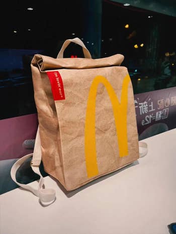 A McDonald's themed backpack styled to look like a takeout bag, positioned on a counter