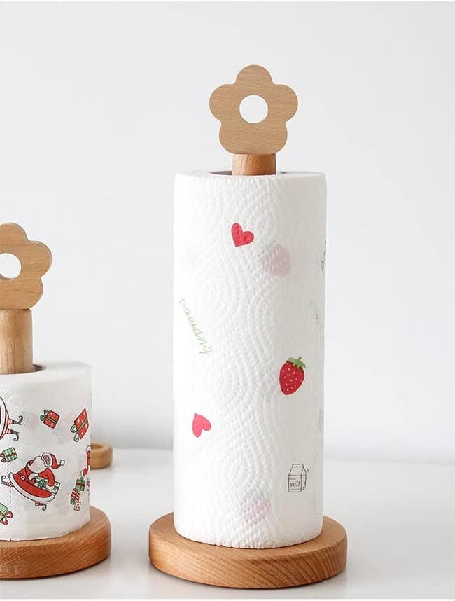Two paper towel holders with unique floral designs on top, one large and one small, with decorative towels