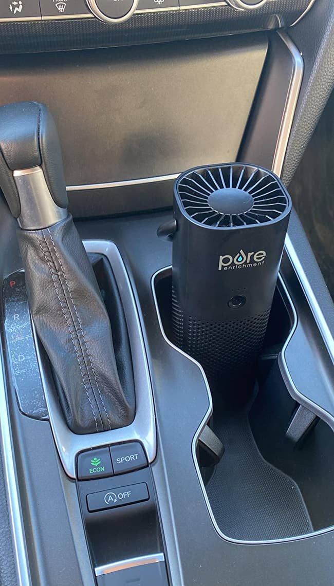 a reviewer shows the purifier in the cup holder