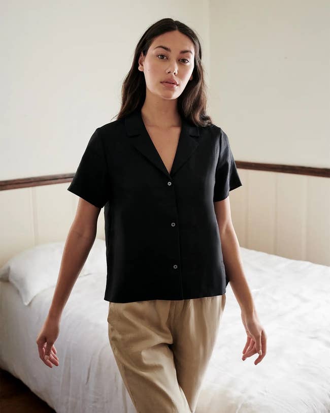 model wearing the short-sleeve button down shirt in black