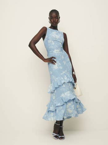 model in a ruffled floral blue dress and heels 