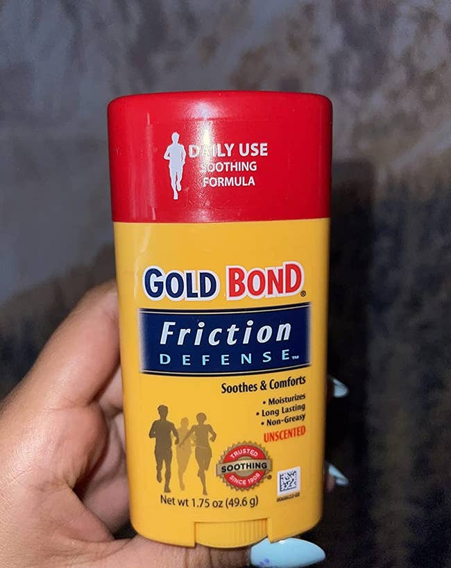 reviewer holding up a tube of gold bond friction defense 