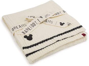 a cream colored scarf with two black stripes and a mickey icon on it