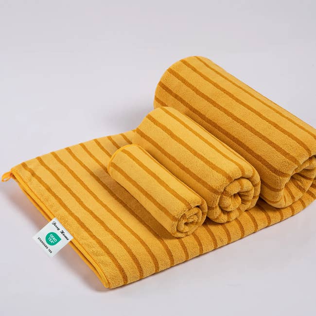 Stacked acceptable   of striped towels successful  antithetic  sizes, with a disposable   tag indicating the marque  and attraction   instructions