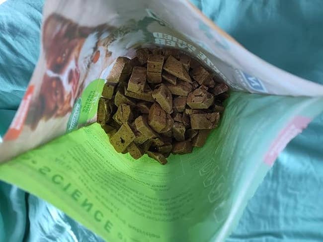 Open bag of pet treats showing cube-shaped snacks inside