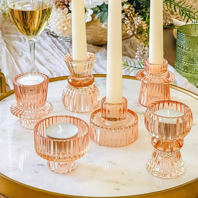 Glass candle holders with ribbed plan displayed connected a circular array with a solid of vino successful the background. Elegant floral statement nearby