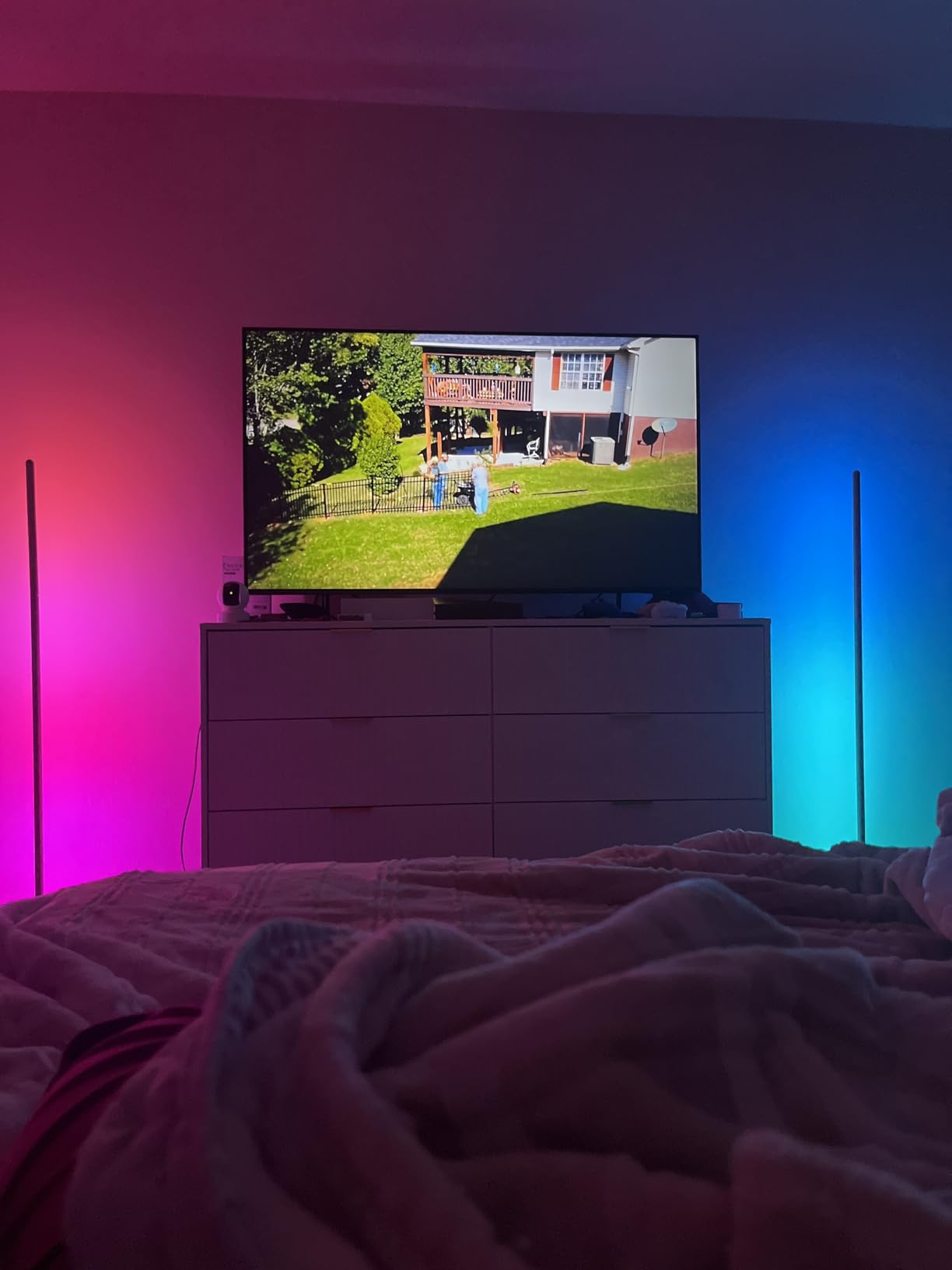 TV connected  a dresser displaying a backyard scene. A furniture  with a broad  is successful  the foreground, with ambient lighting connected  either broadside  of the TV