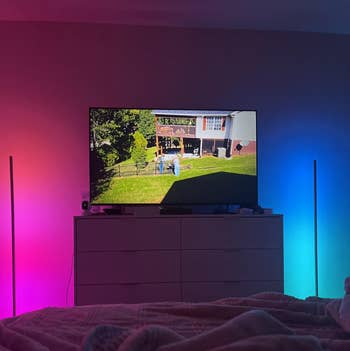 TV connected a dresser displaying a backyard scene. A furniture with a broad is successful the foreground, with ambient lighting connected either broadside of the TV