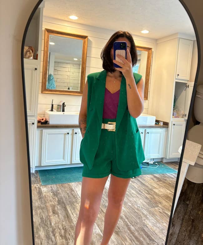 reviewer taking reflector selfie and wearing two-piece shorts and vest acceptable successful green