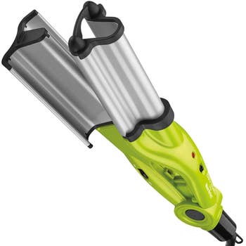 Handheld garment steamer with a metal faceplate and green accents