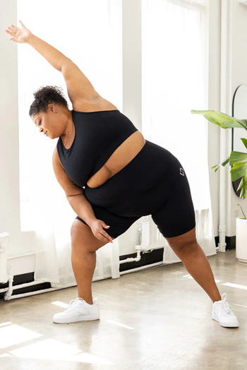 Model stretching in a black workout set