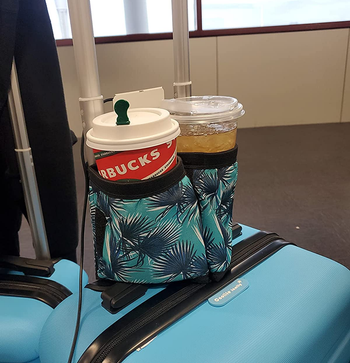 reviewer's two to-go coffee cups in the blue leaf design caddy