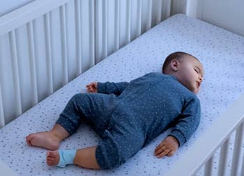 a baby in a crib with the monitoring sock