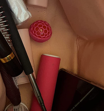 the pink cleaning ball at the bottom of a reviewer's bag