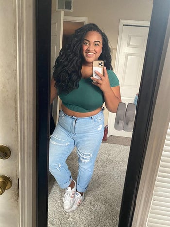 reviewer in dark green crop top and high-rise ripped jeans