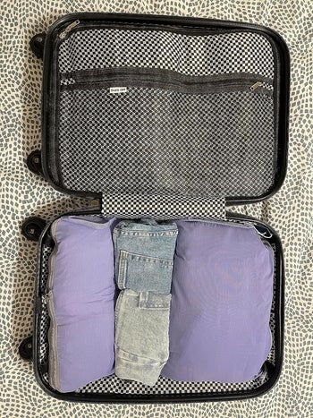 a top-down view of the open suitcase filled with clothes 