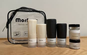 a BuzzFeed writer's travel toiletries: four bottles, three jars, and a bag