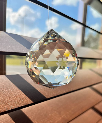 a reviewer photo of one of the prisms hung in front of a window 