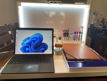 a white briefcase open to show spots for a laptop, chargers, a dry erase board, and storage 