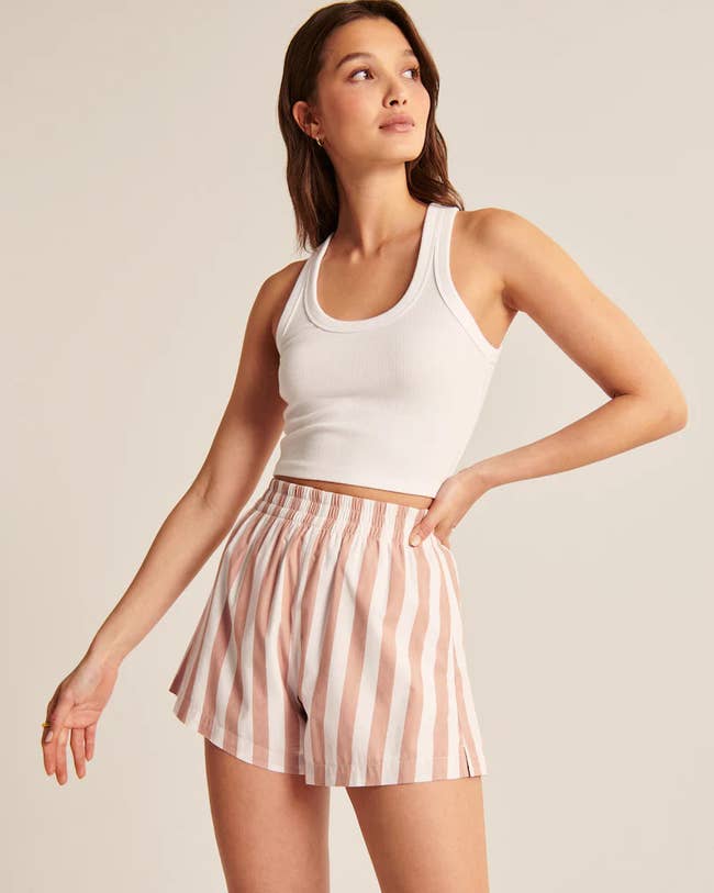 model wearing the pink and white striped-shorts with a cropped white tank top