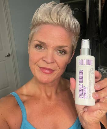 Person holding a vessel of Bold Uniq Purple Toning Shampoo