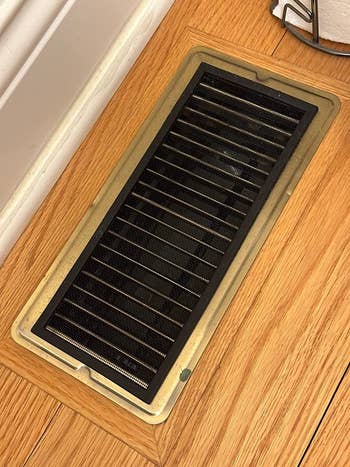 reviewer photo of the black mesh vent cover on a floor vent