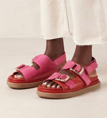 model wearing pink and red buckle-strap sandals