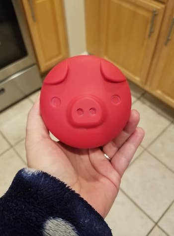 reviewer holding pig shaped bacon grease container
