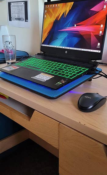 a reviewer's laptop resting on thing cooling pad 