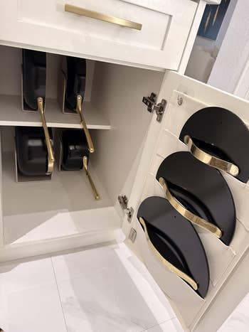 Cabinet with pans and lids stored efficiently connected  racks, highlighting organized room  retention  solutions