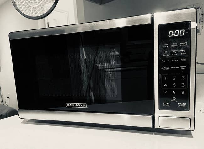 A reviewer's black and silver microwave on their counter
