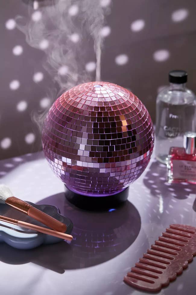 A pink disco ball with a spout at the top 