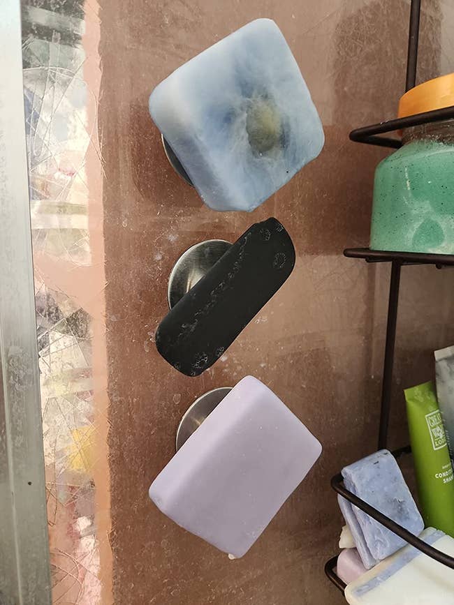 reviewer photo of three magnetic holders with three bars of soap attached