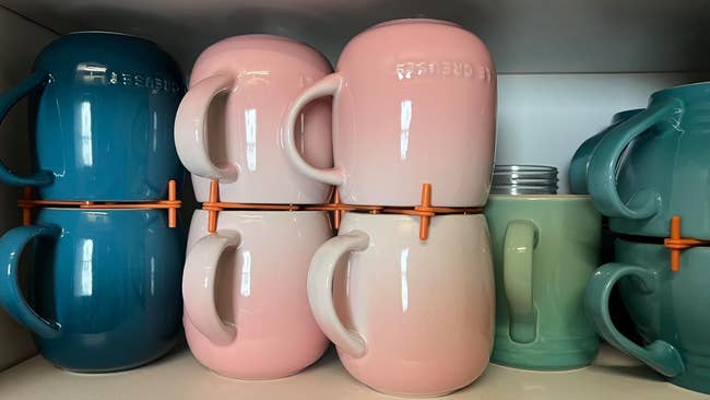 Stacked ceramic mugs with attached spacers connected a support for organized room storage