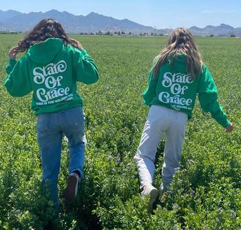 two people wearing green state of grace hoodies