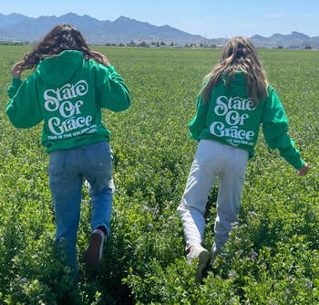 two people wearing green state of grace hoodies