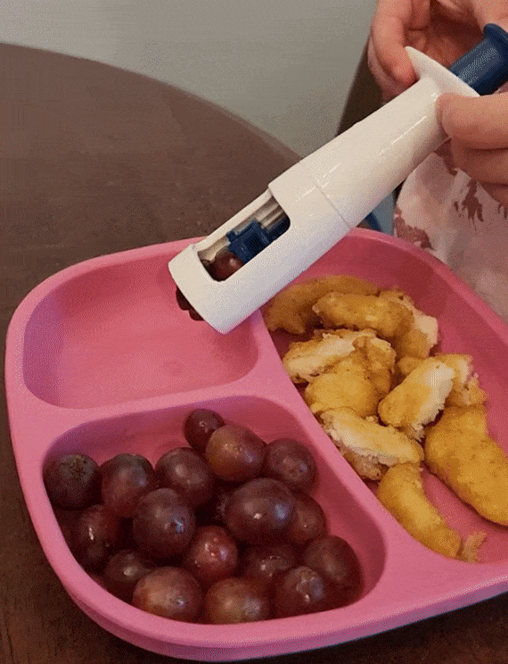 Reviewer using grape cutter onto pink plate