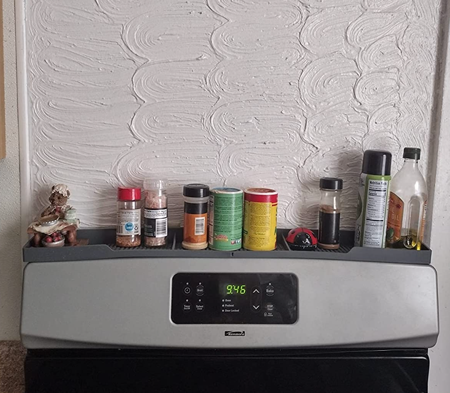 gray silicone shelf attachments on top of a stove holding seasonings