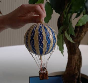 Person's hand holding miniature hot air balloon decoration 