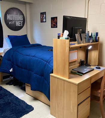 reviewer's blue comforter on a bed in a dorm 