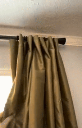 reviewer easily opening a set of curtains on a rod 