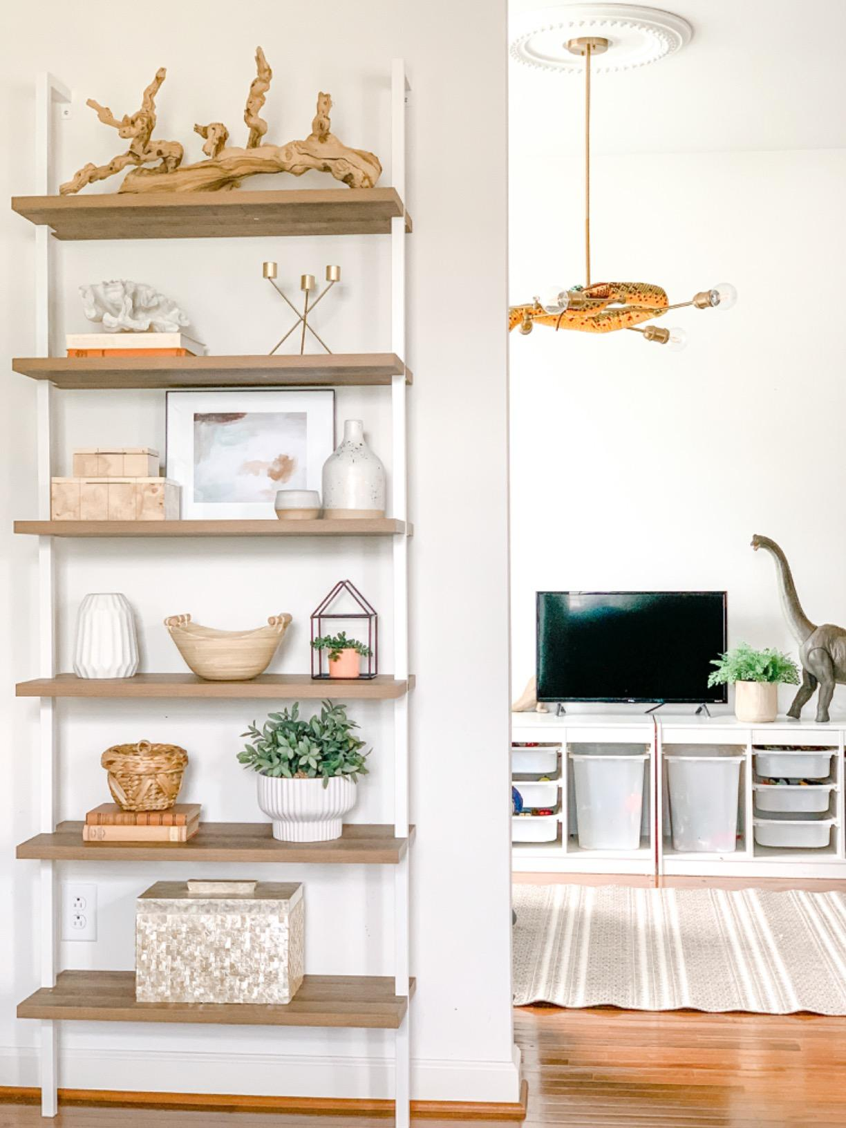 reviewer photo of the white and wood bookshelf holding pieces of decor