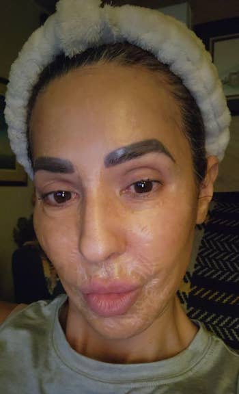 Person with skincare mask and fluffy headband, looking at the camera. They appear to be in a relaxed setting, possibly at home