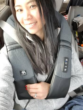 reviewer smiling in a car, wearing a seatbelt, with a ring on her finger