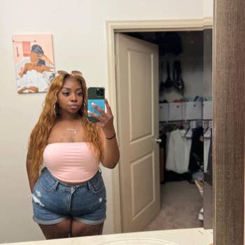reviewer posing for a mirror selfie wearing pink top 