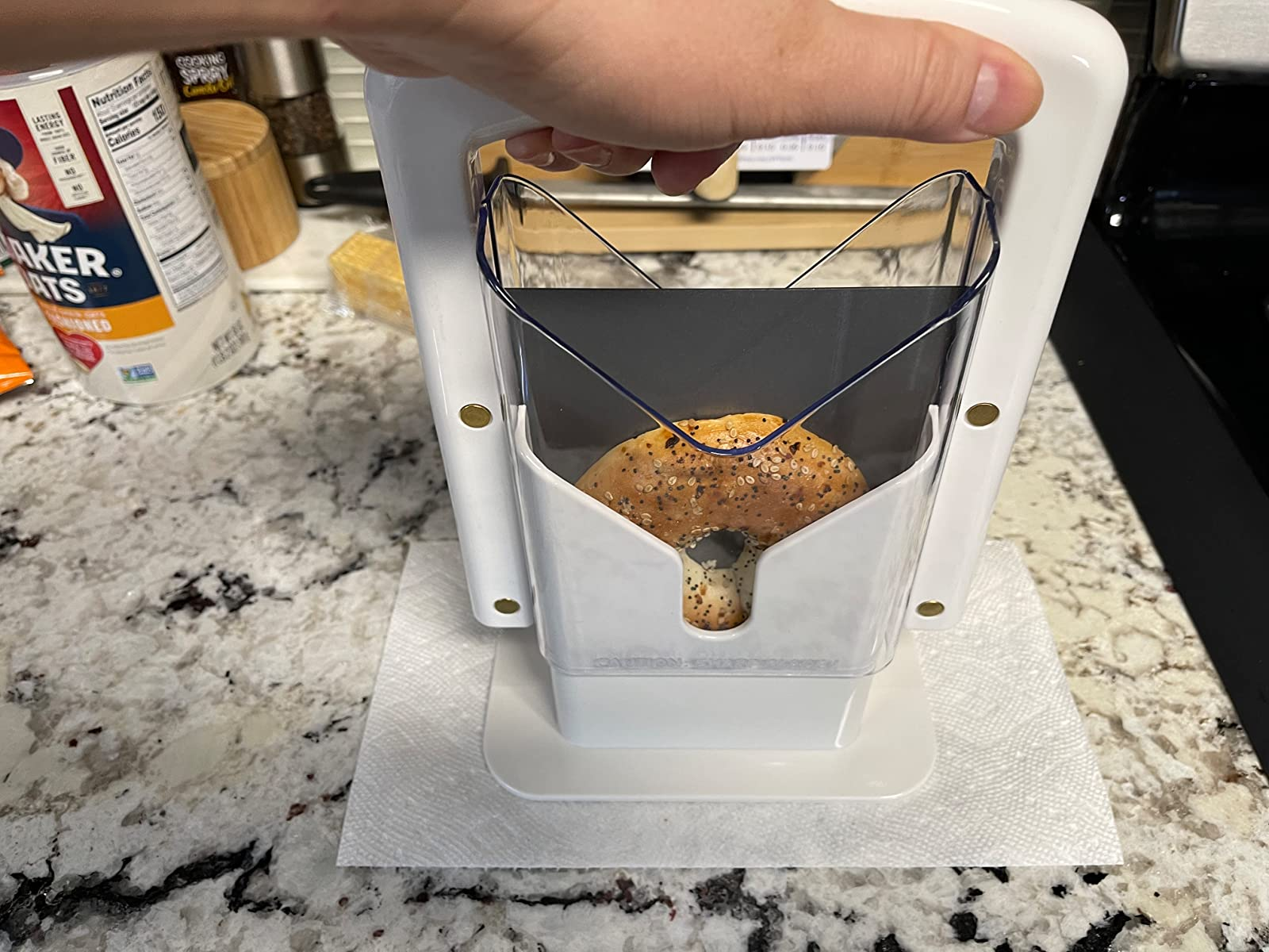 Reviewer pushing down   connected  their bagel guillotine, astir  to portion    their bagel successful  half