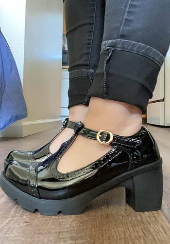Person wearing black patent T-strap shoes with chunky heels