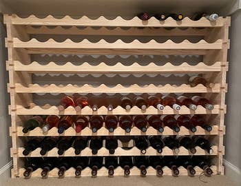 Reviewer image of the light colored wine rack with some wine botles
